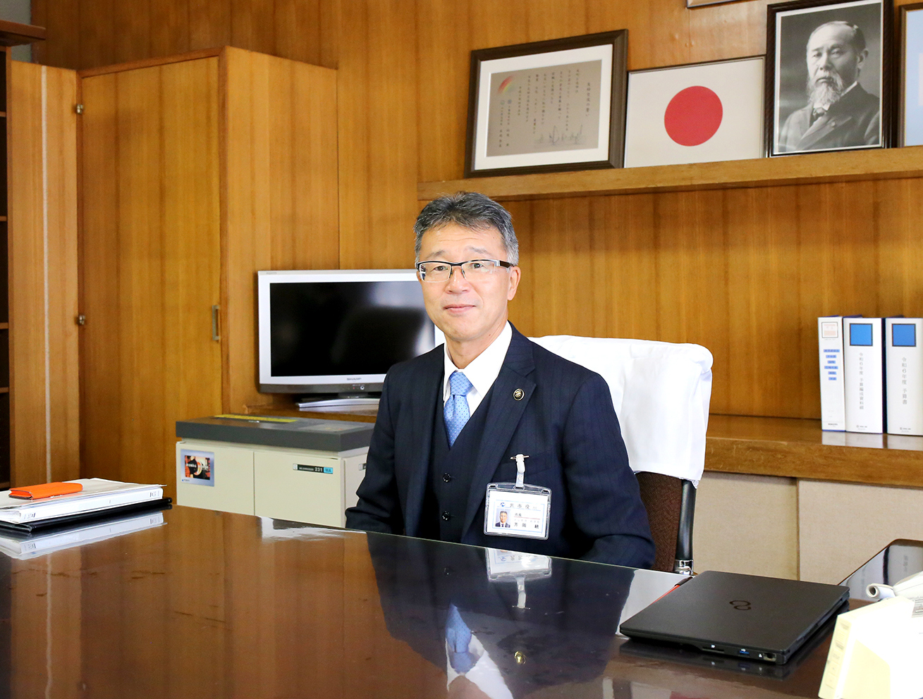 芳岡統市長が椅子に座っている写真