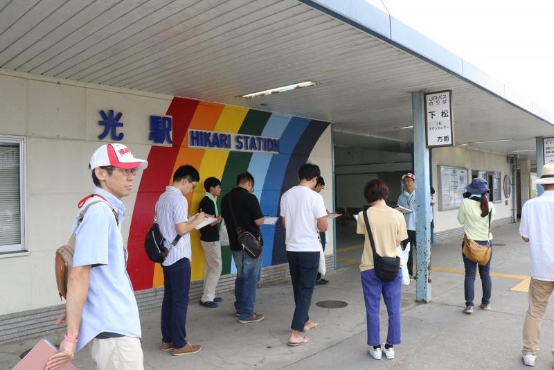 昼間に駅を歩く若者たちの写真