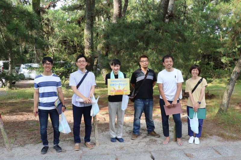 昼間の公園で撮られた若者の男女の集合写真