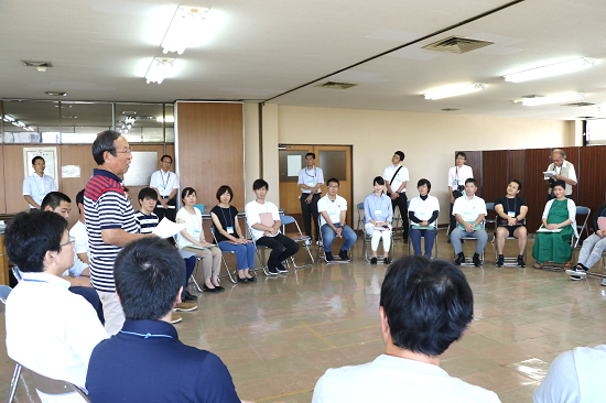 室内で輪になって座る若者たちを横から撮った写真