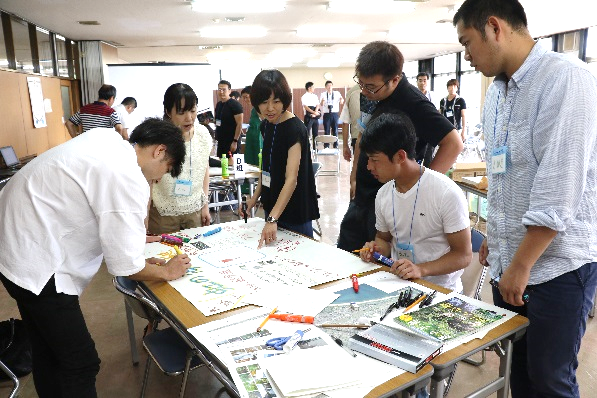 室内で立って話し合う若者たちの写真