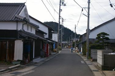 電柱と瓦屋根の民家が写る町並みの写真
