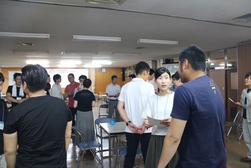 室内で立って話し合いをする若者たちの写真