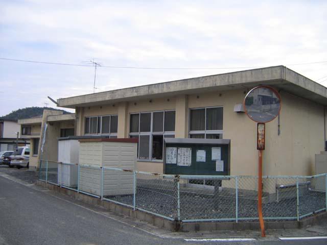 カーブミラーの設置された曲がり角に位置する昭和会館の写真