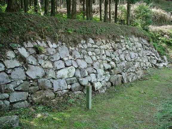 沢山の大きな石を敷き詰めて作った高い石垣壁の写真