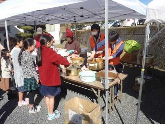 テントの中で振舞われているカレーを並んで待っている女の子たちの写真