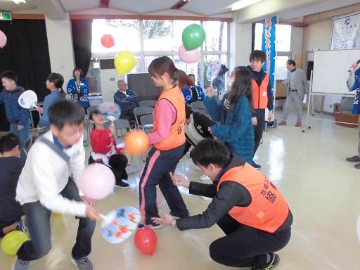 室内イベントで参加者が風船をうちわであおいでいる様子を見守る隊員の写真