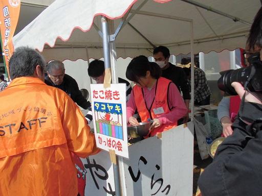 隊員とスタッフがたこ焼きをテントの中で作っている写真