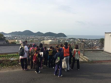 展望台から遠くの街並みを見下ろしているウォークラリー参加者らの写真