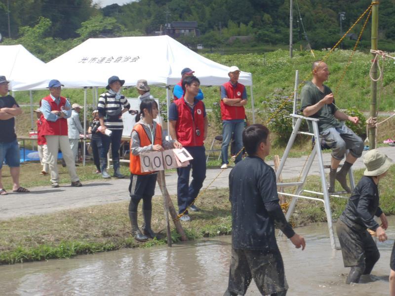 どろんこバレーの審判と点数係の人や主催者が試合を見ている写真