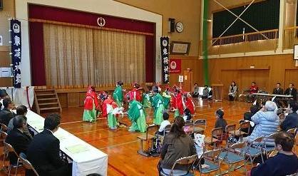 束荷ふれあい文化祭で、緑と、赤の衣装を着て丸く並ぶ生徒の写真