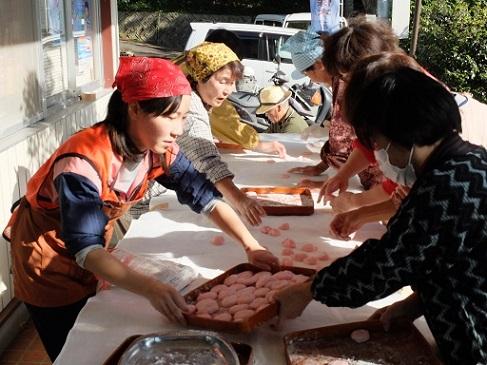 ピンクの餅を丸める地域ふれあい協働隊の女性と地域の女性たちの写真