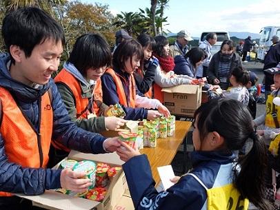 隊員やスタッフから参加者の子供たちにお菓子が配られている写真