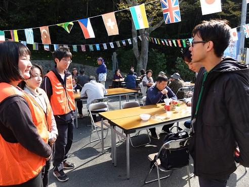 オレンジ色のベストを着た地域ふれあい協働隊と埼玉県宮代町の男性職員が話しをしている写真