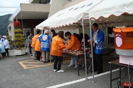 テントの中でスタッフの方がたこ焼きなどの軽食を準備している写真