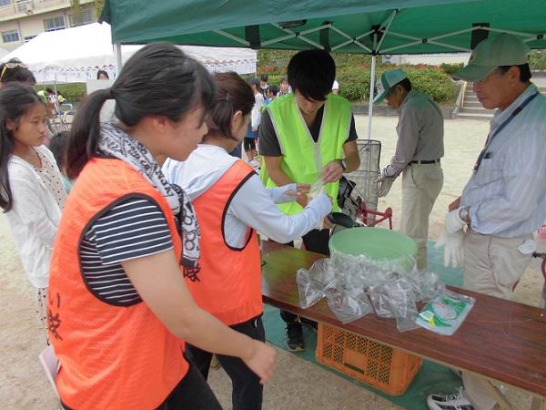 テントの中で作られているポン菓子を袋に入れている隊員の写真