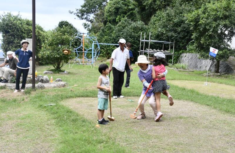 ゲートボールでホールインワンを決めた女の子と年配の女性が抱き合って喜んでいる写真