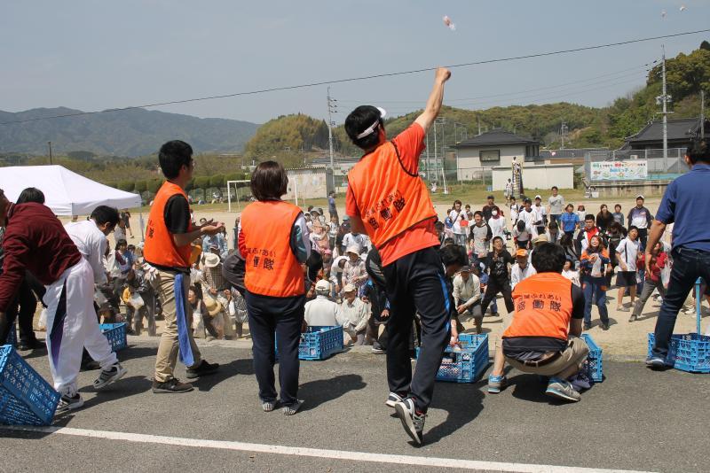 隊員たちがもちまきをしたものを拾おうとしている大勢の参加者の写真