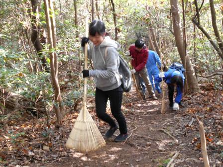ガンザキで山道の小枝や落ち葉の清掃をしている参加者の写真