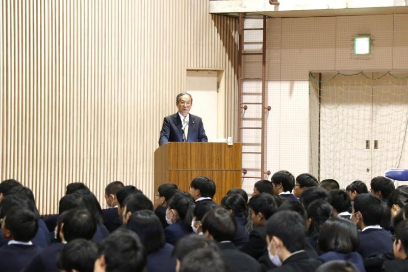 演台から学生たちに向けて笑顔を見せる市長の写真