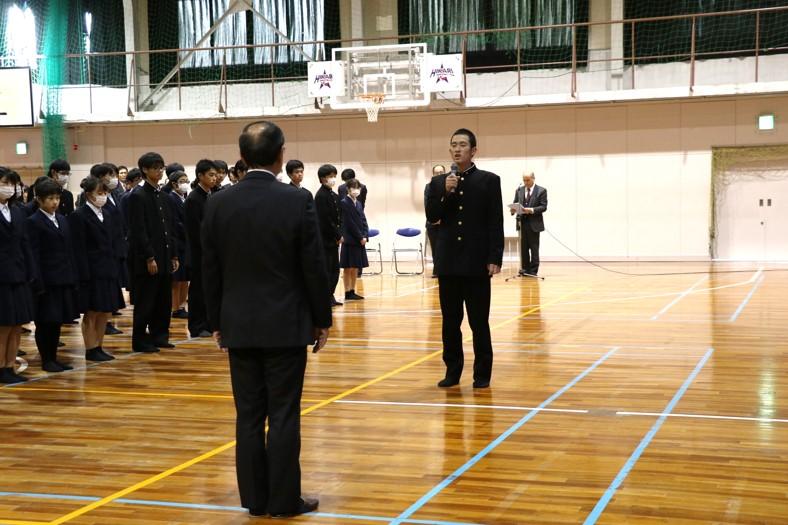 男子学生が市長のほうを向いてマイクを手に話している写真