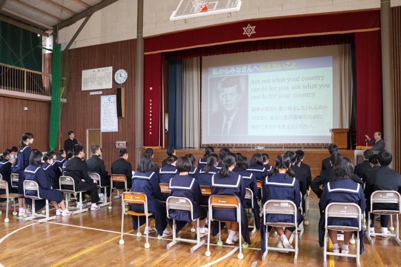 スクリーンに映し出された映像を見ながら話す市長とそれを聞く学生たちの写真