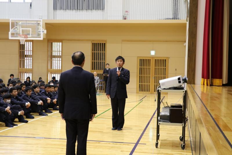 マイクを手に持った男子学生が市長と向かい合っている写真