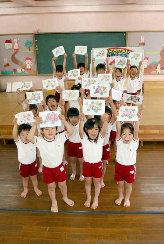 大和保育園の園児一人一人が完成したあじさいのぬり絵を両手で高く持ち上げ見せている写真