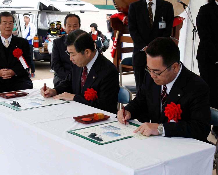 白いテーブルで書類にサインをする男性の写真