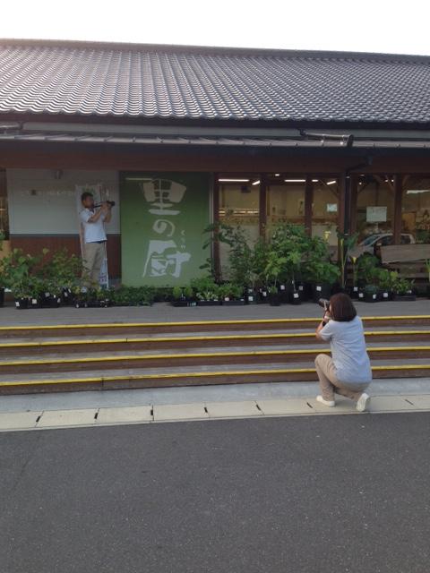 和風の建築物の前にいる人物とその手前にいる膝をついた体制の人物が動画を製作している様子の写真