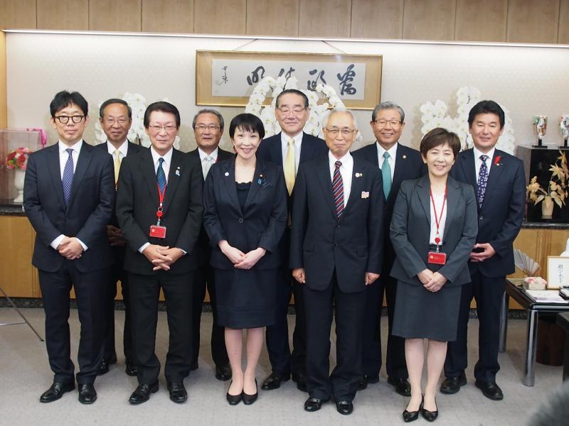 スーツを着た人物たちが2列に並び撮影した記念写真