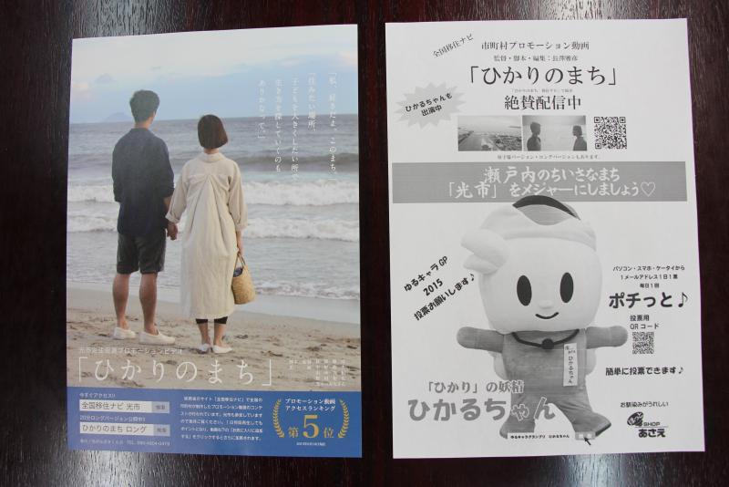 2人の人物が写ったものとマスコットキャラクターが写った2種類のチラシを撮影した写真