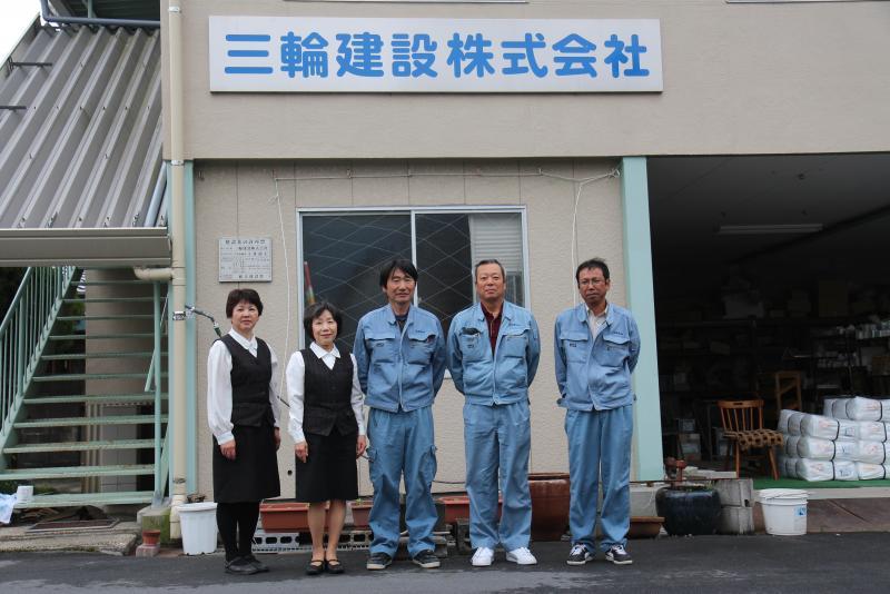 三輪建設株式会社の前で撮られた三輪建設株式会社の従業員の集合写真