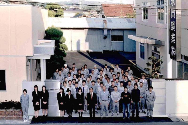 永岡鋼業株式会社の前で撮られた永岡鋼業株式会社の従業員の集合写真