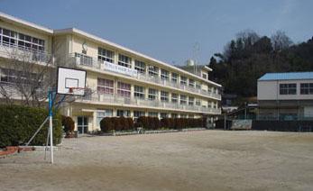 バスケットゴールのある校庭と光市立上島田小学校外観の写真