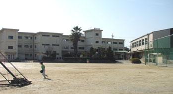 校庭で遊ぶ子どもと光市立島田小学校外観の写真