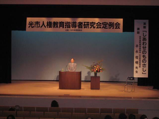 ステージ上で参加者に向けて話をする人の写真