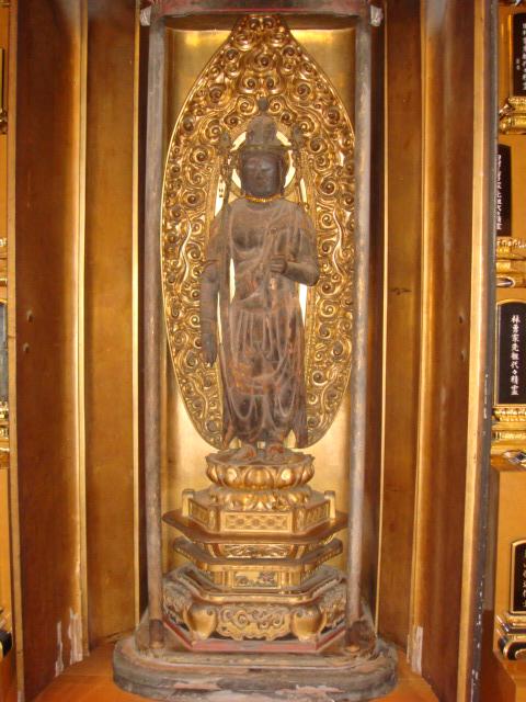 右手は体にそって下げ、左手は前方に上げ、蓮台上に立っている木造十一面観世音菩薩立像の写真