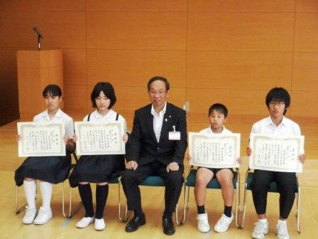 表彰された小・中学校の生徒が市長と一緒に座って記念写真