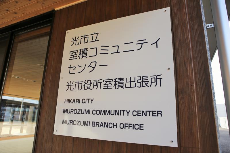 日本語と英語表記で書かれてある光市立室積コミュニティセンター光市役所室積出張所の看板の写真