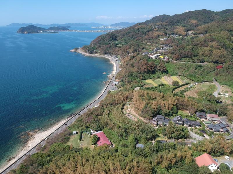 伊保木コミュニティセンター上空から浦田の町並みと海を撮影した写真