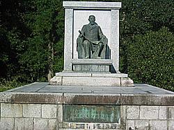 植え込みの傍で大きな台座の上に鎮座する伊藤公銅像の写真