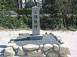 晴れた空の下、植え込みを背景に写る三隅塾跡記念碑の写真