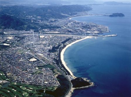 空中から海辺と隣接する町の市街地を撮影した写真