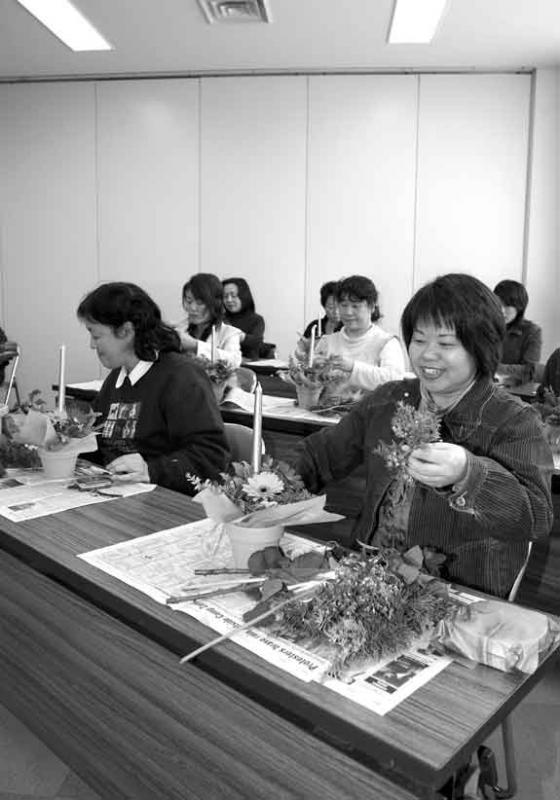 フラワーアレンジメント教室で女性たちがオリジナルキャンドルを作っている写真