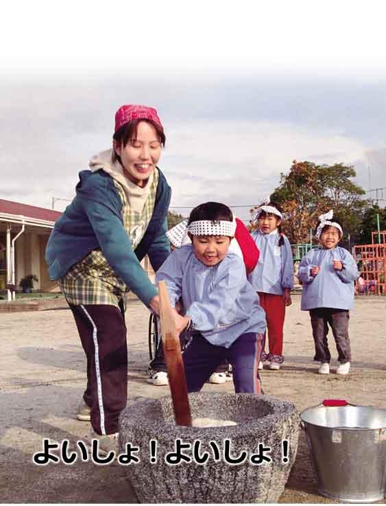 よいしょ！よいしょ！鉢巻きをしている園児が先生と一緒に餅つきをしている写真