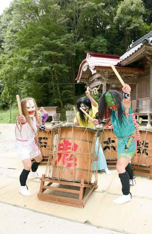 般若のお面を被った石城太鼓保存会の方が須賀社の境内で太鼓を叩いている写真