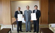 合併決定書を持って並ぶ光市長と大和町長と県知事の写真