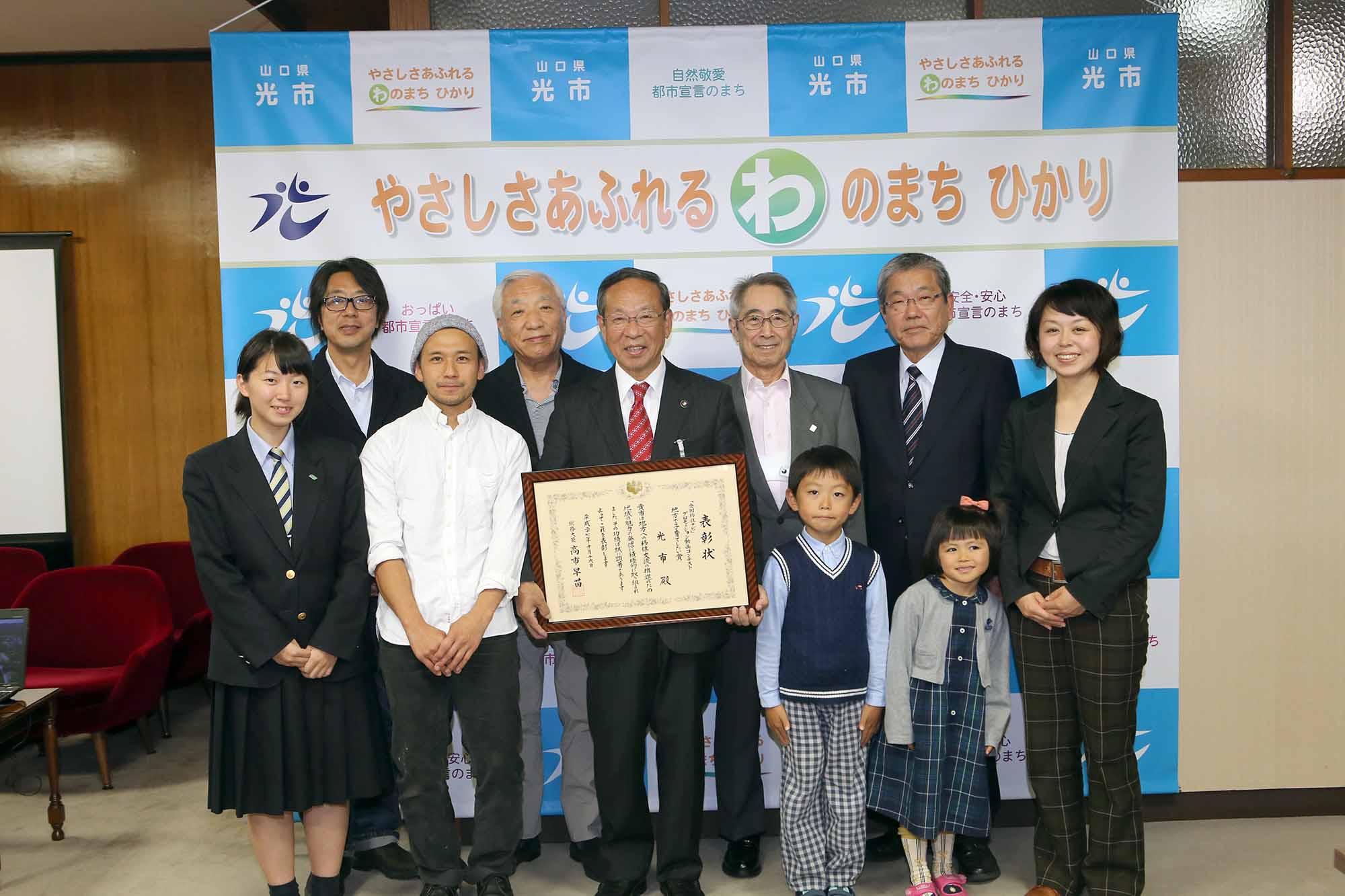 「ひかりのまち」の総務大臣表彰に係る報告会の集合写真