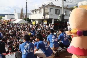 きゅっとちゃんたちが舞台の上からお餅をまいています